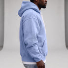 Man wearing light blue relaxed hoodie with white drawcords, side view | Chaps London