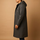 Man wearing dark green long hooded raincoat with snap front, side view | Chaps London