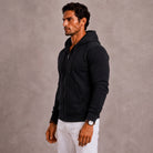 Man wearing black full-zip hoodie with hood, paired with white trousers | Chaps London