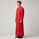 Man wearing long red button-front cassock with stand collar, side view | Chaps London