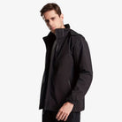 Man wearing black waterproof hooded rain jacket with standing collar, side view | Chaps London