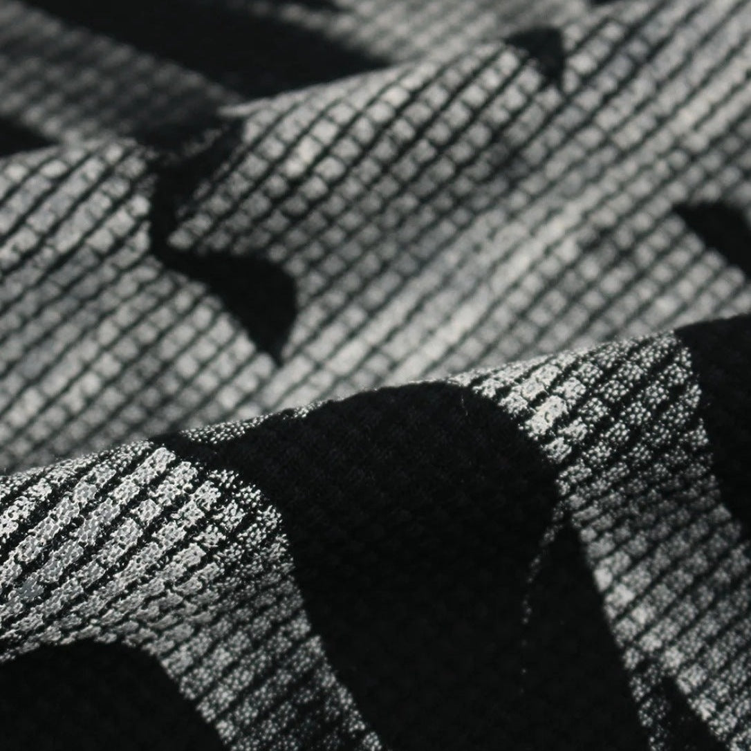 Close-up of black and white waffle-textured fabric with abstract pattern | Chaps London