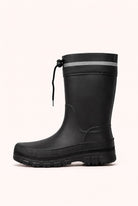 Side view of a black mid calf rain boot with a black lugged sole, a reflective band and a drawstring at the top.