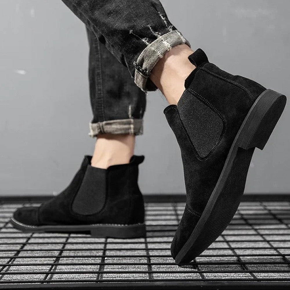 Black faux suede Chelsea boots worn by person on grid floor | Chaps London