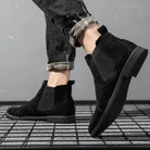 Black faux suede Chelsea boots worn by person on grid floor | Chaps London