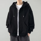 Black oversized zip hoodie worn by man, drawstring hood, front pockets visible | Chaps London