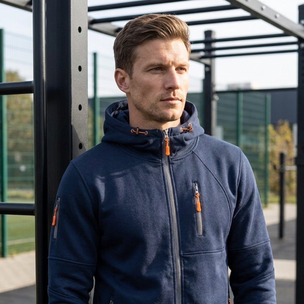 Man wearing navy zip hoodie with orange pullers outdoors on sports court | Chaps London
